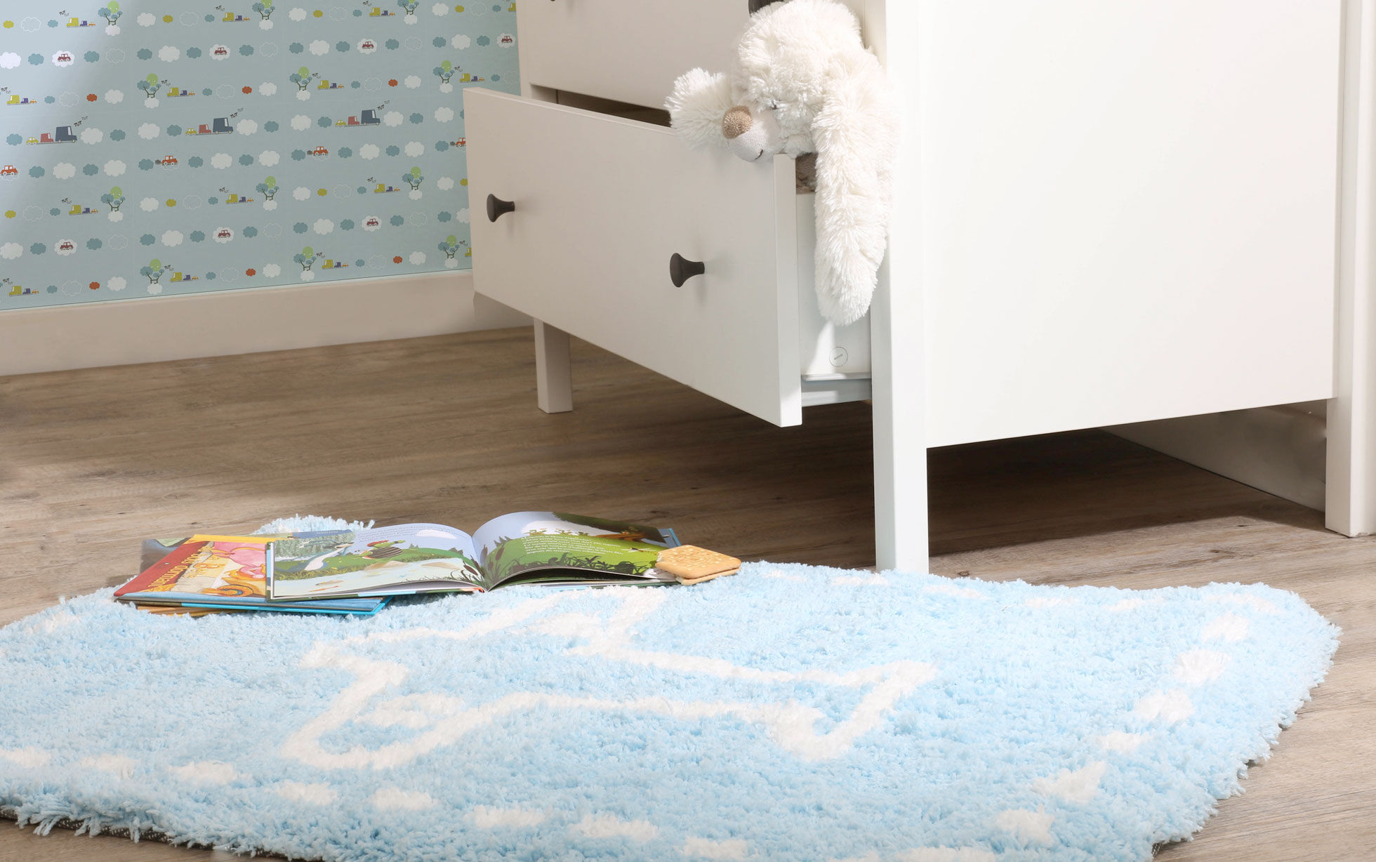 Tapis bleu pour enfant devant une commode blanche