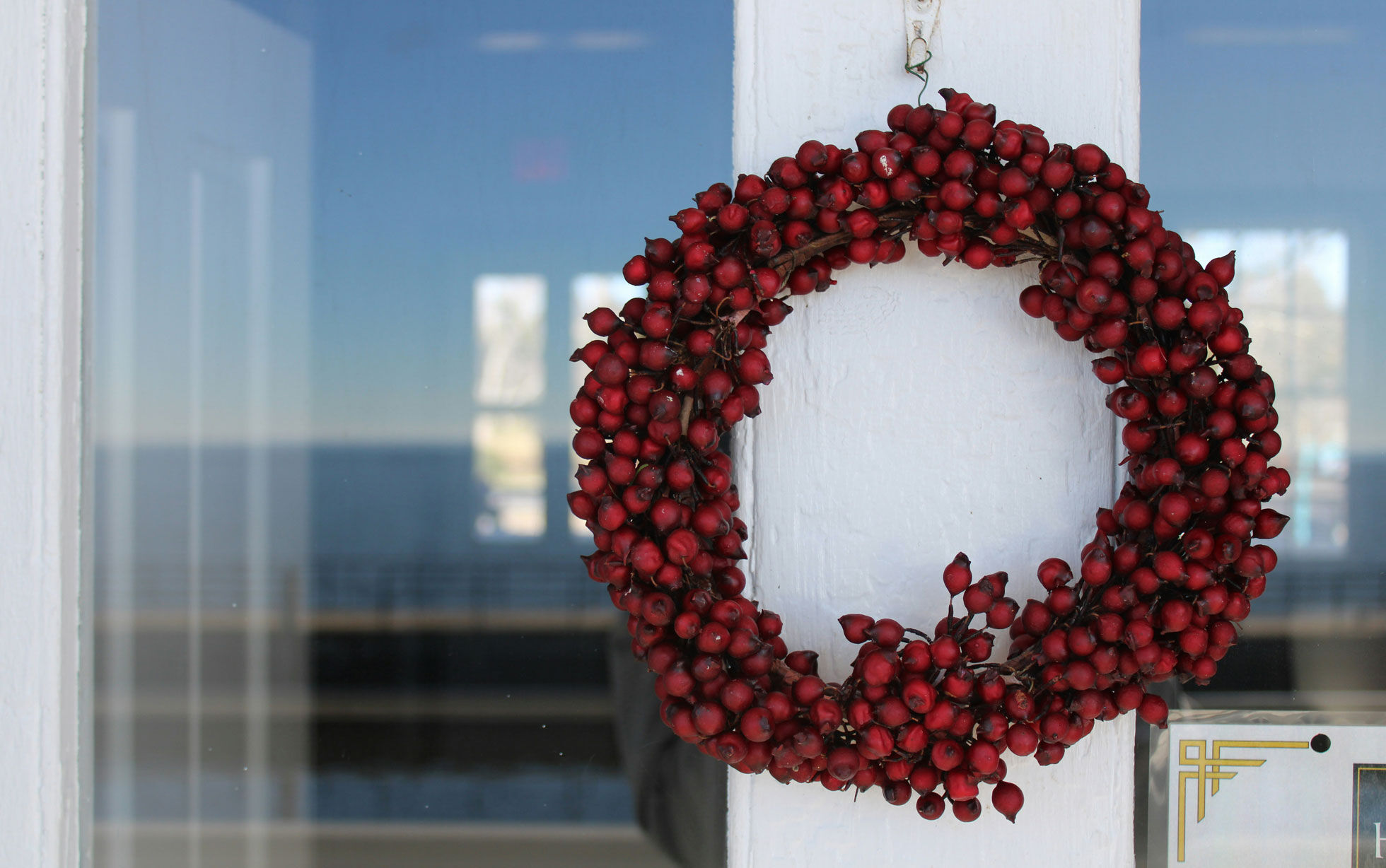 couronne de baies rouges sur une porte blanche