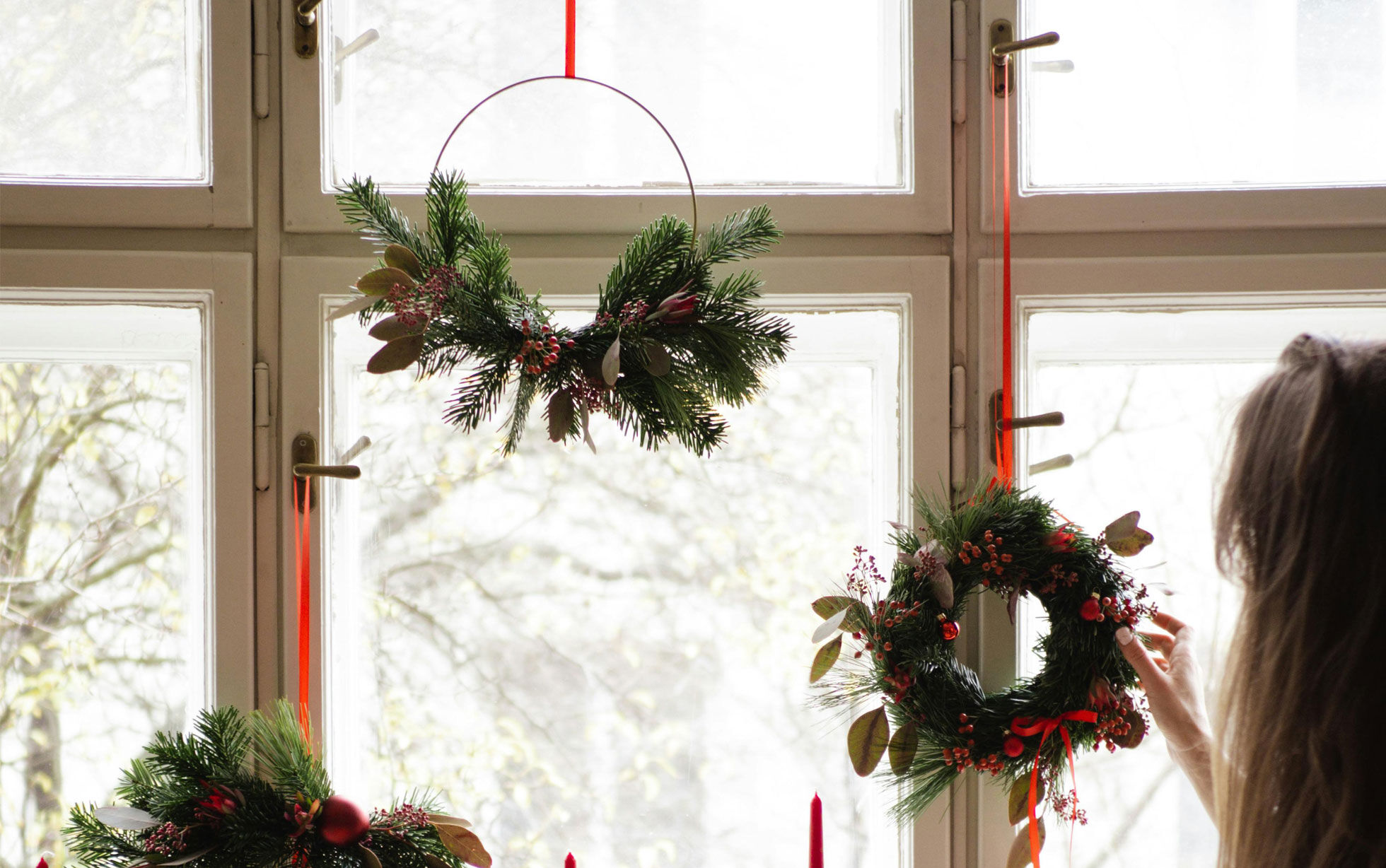 Weihnachtskränze Tannenzweige aufgehängt am Fenster
