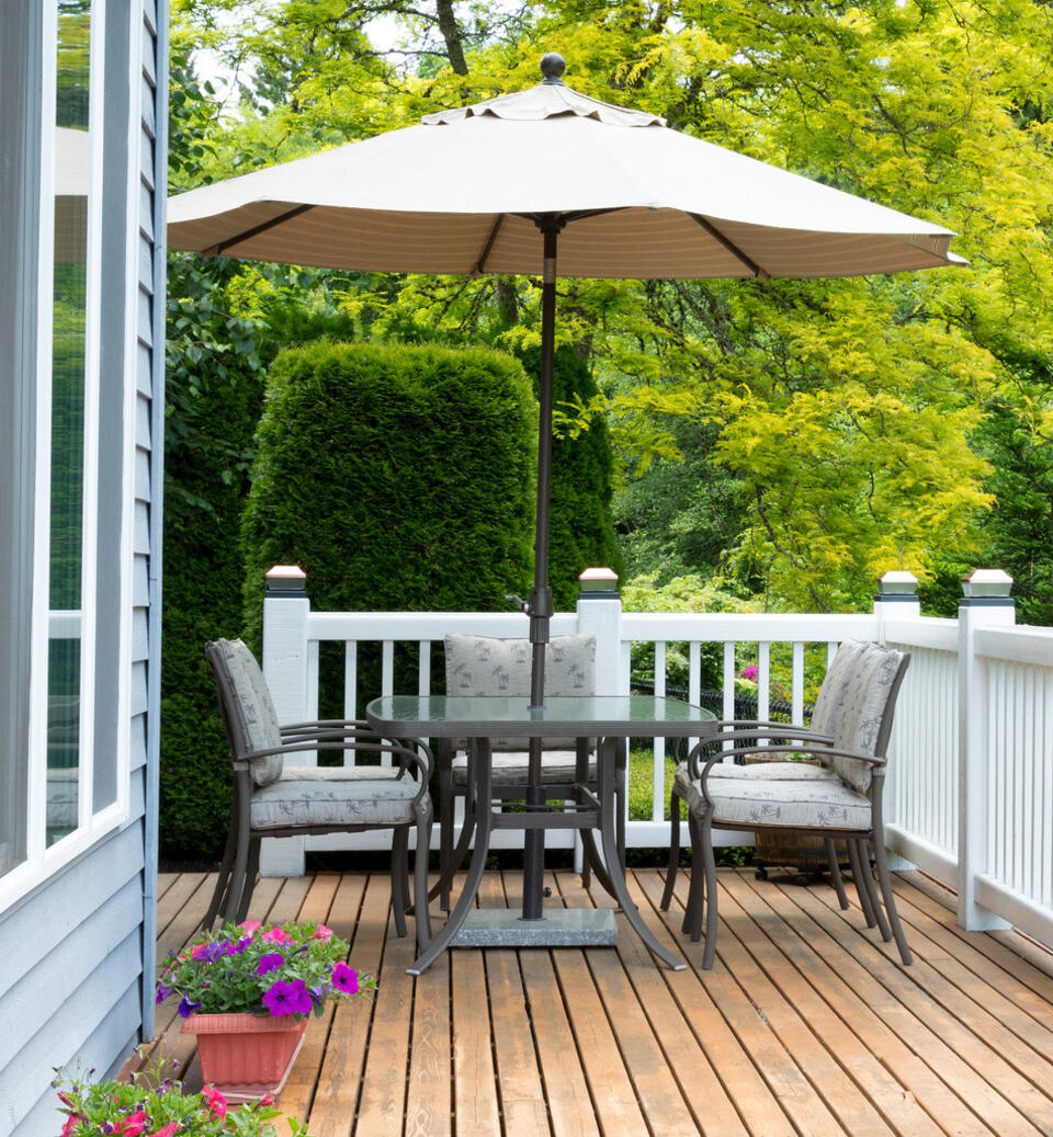 mesa de jardín con parasol redondo en una terraza