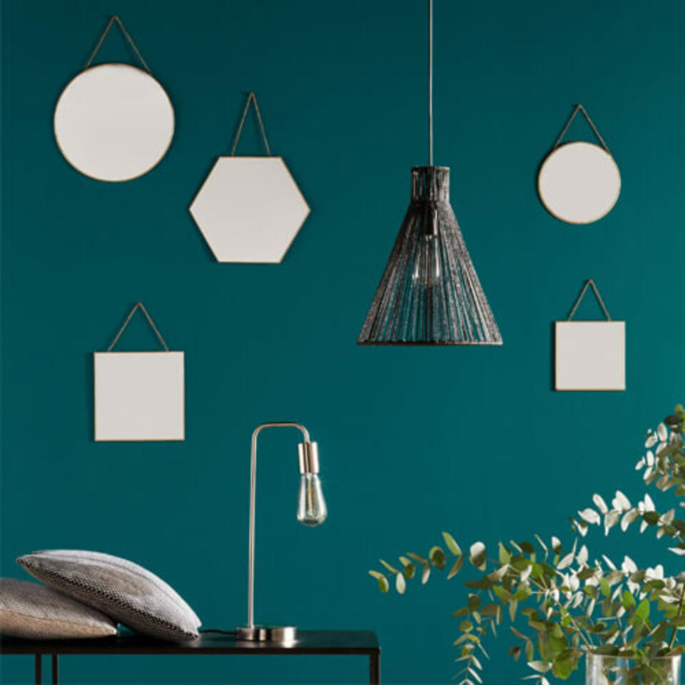 espejos redondos, hexagonales y cuadrados sobre una pared verde