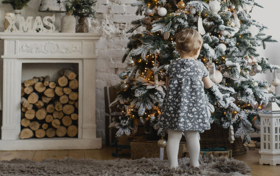 niño delante de un árbol de Navidad artificial con LED